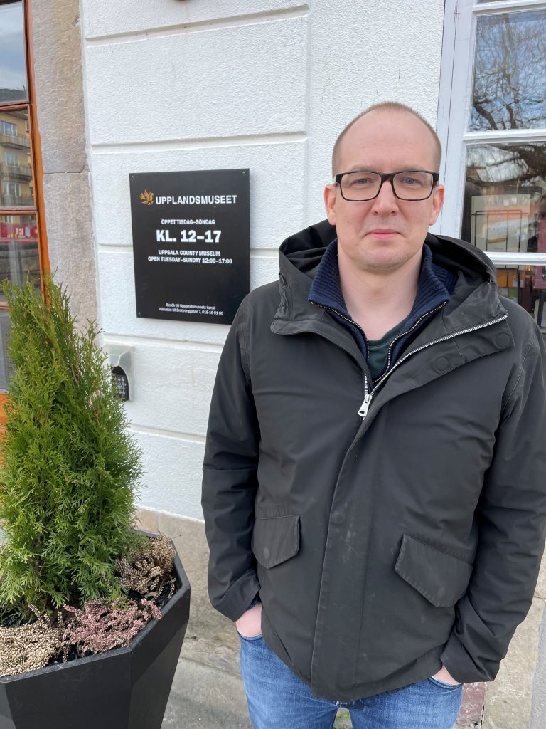 Jani Ylén står utanför Upplandsmuseet med en jacka.