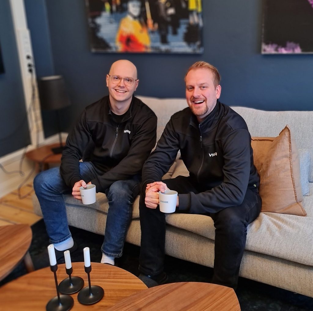 Två medarbetare på VMAR sitter och skrattar tillsammans i en lounge. 